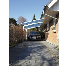 Abri de voiture avec voiture sur allée pavée