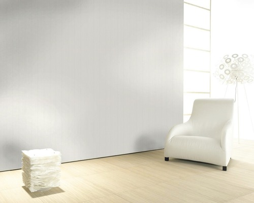 Pièce lumineuse avec papier peint uni, fauteuil et lampe