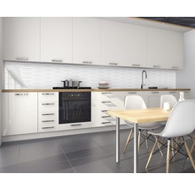 Cuisine moderne avec armoires blanches, évier, plaque de cuisson, table à manger et revêtement mural structuré.