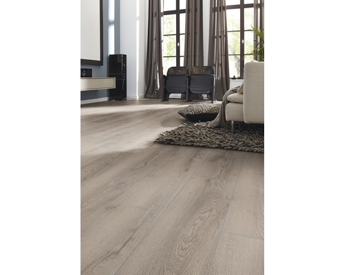 Heller Wohnraum mit Laminatboden in Holzoptik, Sessel, Teppich und Vorhängen