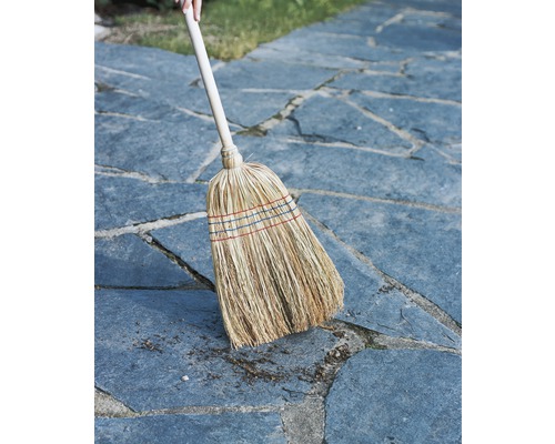 Strohbesen mit Holzstiel auf Pflastersteinen