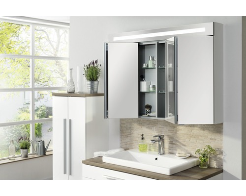 Salle de bains avec lavabo, armoire de toilette, meuble bas et fenêtre pour la lumière du jour