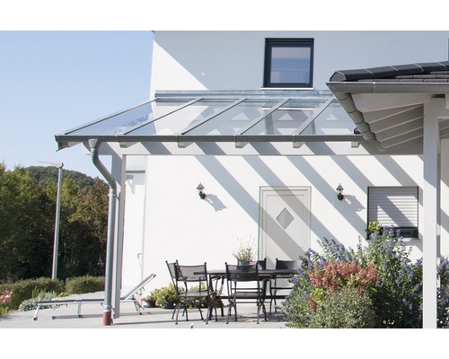Terrasse avec toit en verre et mobilier de jardin par une journée ensoleillée