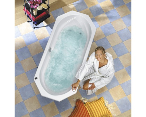 Frau im Bademantel an einer gefüllten Badewanne mit Whirlpoolfunktion