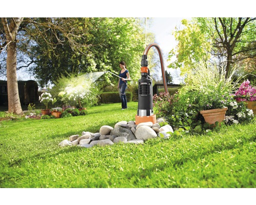 "Garten mit einer Tauchdruckpumpe im Einsatz, umgeben von Steinen und Pflanzen