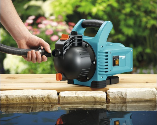 Gardena Gartenpumpe mit angeschlossenem Schlauch neben einem Teich