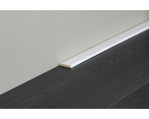 Weiße Fußleiste an einer Wand über einem dunklen Holzboden