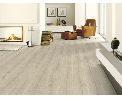 Salon lumineux avec cheminée, fauteuil et sol stratifié