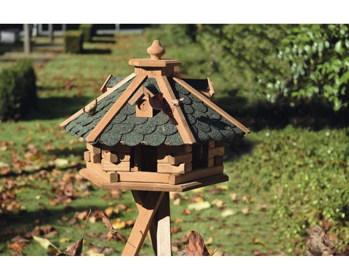 Vogelhaus aus Holz mit Ständer im Garten.