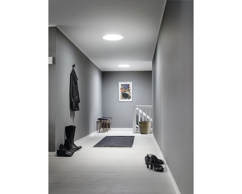 Couloir avec spots de lumière naturelle, banc, tapis, chaussures et veste