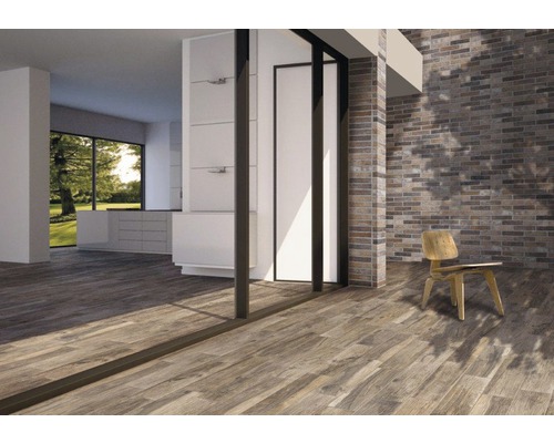 Heller Raum mit Holzfußboden, Backsteinwand und Stuhl.