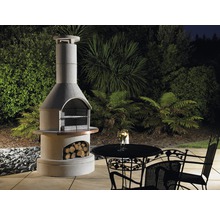 Gril de jardin en maçonnerie avec compartiment de rangement pour le bois, table et chaises dans le jardin