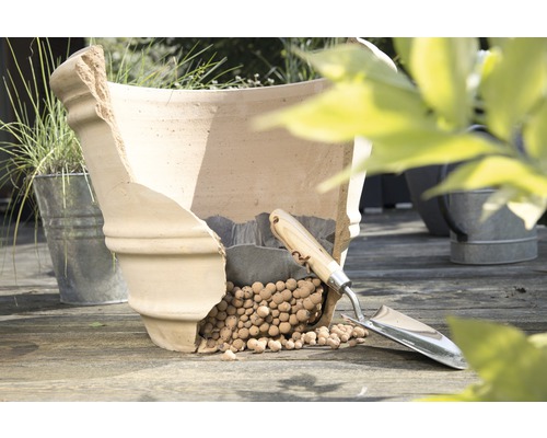 Pot de fleurs en terre cuite endommagé avec billes d''argile et transplantoir