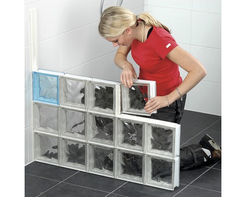 Frau montiert Glasbausteine im Badezimmer