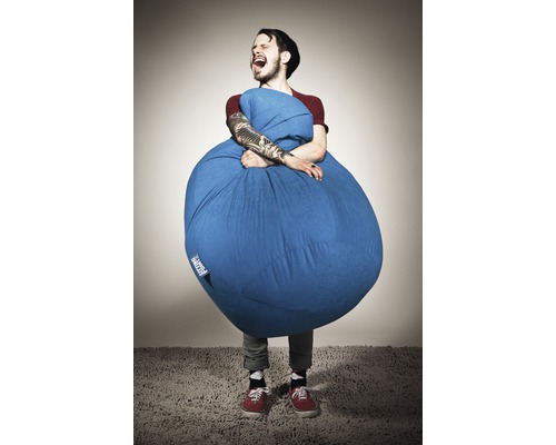 Un homme étreint un pouf bleu à l''intérieur