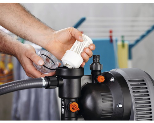 Une personne insère un filtre dans une pompe de jardin.