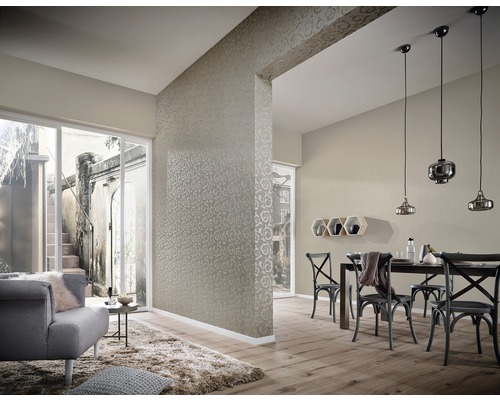 Salon avec papier peint, table et chaises de salle à manger et coin salon avec fauteuil