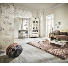 Wohnzimmer mit floraler Tapete, Sofa, Teppich und Holzfußboden für ein helles Ambiente.