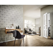 Wohnzimmer mit Schreibtisch, Stuhl, Sofa und gemusterter Tapete