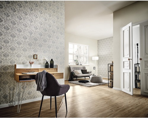 Wohnzimmer mit Schreibtisch, Stuhl, Sofa und gemusterter Tapete