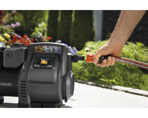 Gartenpumpe mit angeschlossenem Schlauch im Garten