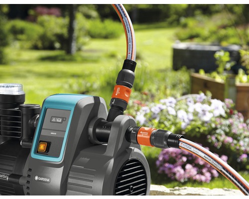 Gartenpumpe mit angeschlossenen Gartenschläuchen im Aussenbereich