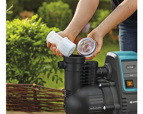 Frau setzt Filter in eine Gartenpumpe ein.