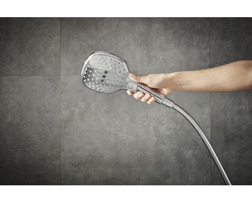 Hand die einen Duschkopf mit Schlauch hält.