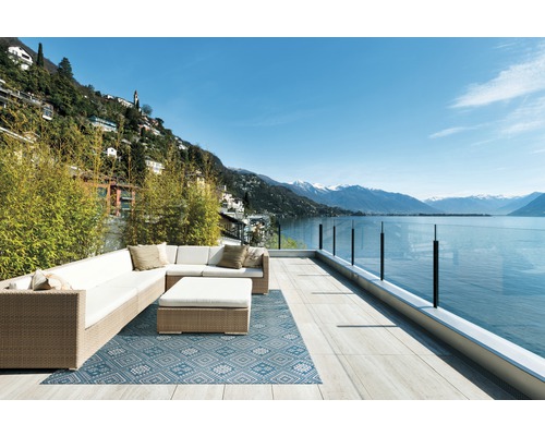 Außenbereich mit Ecksofa, Couchtisch und blau gemusterter Outdoor Teppich mit Blick auf einen See