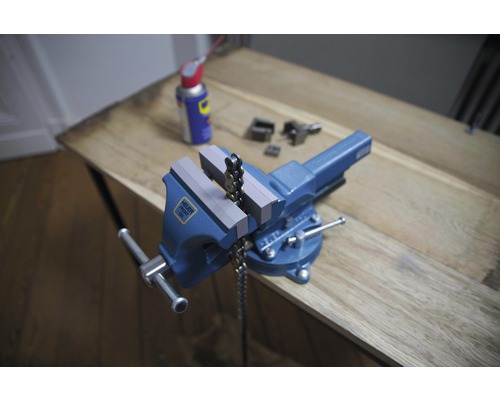 Blauer Schraubstock mit Kette auf einer Holzoberfläche