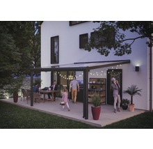 Terrassenüberdachung mit sitzenden Personen und Beleuchtung am Haus