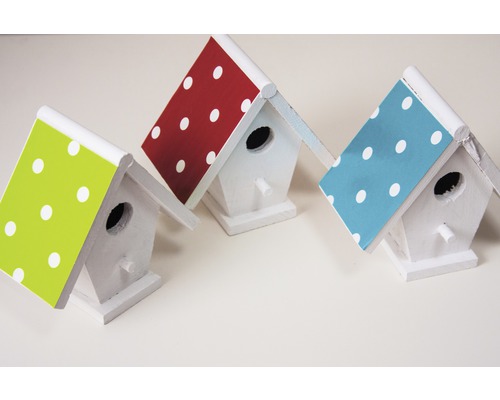 Trois nichoirs blancs avec des toits à pois