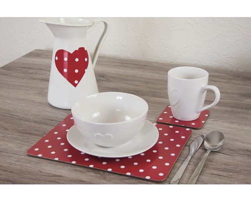 Couverts de table décoratifs avec cruche, bol, tasse, assiettes, dessous de verre et couverts sur une table