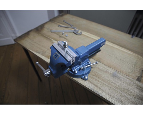 Blaue Werkbank mit Schraube und Muttern auf Holztisch