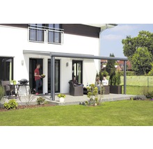 Terrasse mit Terrassenüberdachung, Gartenmöbeln und Personen vor einem Wohnhaus