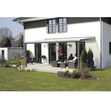 Terrasse mit Terrassenüberdachung an einem Wohnhaus mit Gartenmöbeln und Grill