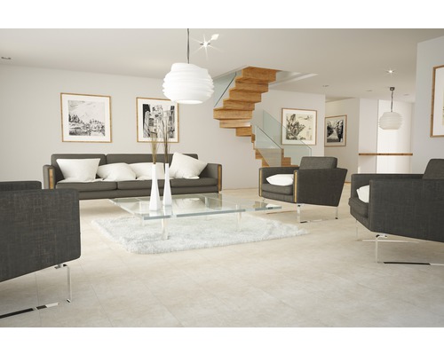 Salon lumineux avec canapé, fauteuils, table en verre et escalier en bois