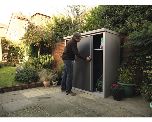 Mann öffnet Gartenschrank mit Schiebetüren zur Aufbewahrung von Gartengeräten im Garten.