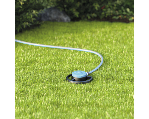 Rasensprenger mit Schlauch auf Rasen