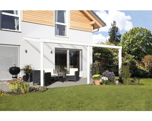 Terrasse couverte avec mobilier de jardin et barbecue devant une maison d''habitation.