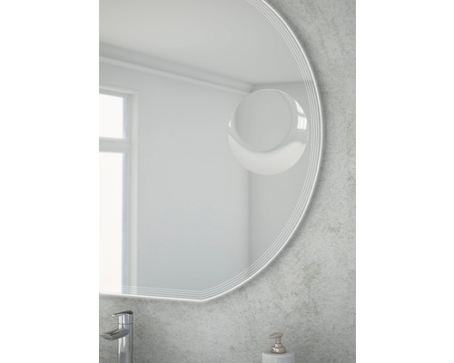 Gros plan d''un miroir rond dans une salle de bain avec robinet et distributeur de savon