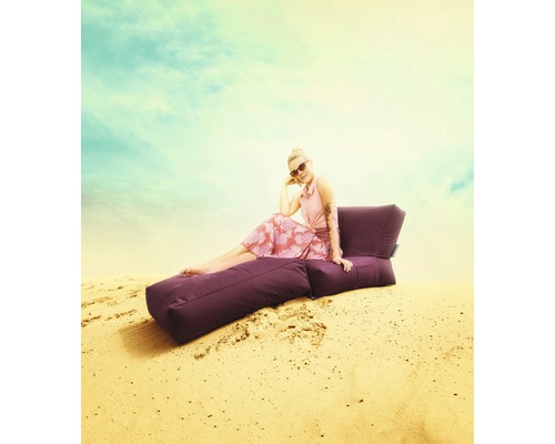 Frau sitzt auf einem lila Sitzsack im Freien