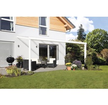 Überdachte Terrasse mit Gartenmöbeln und Grill neben dem Haus