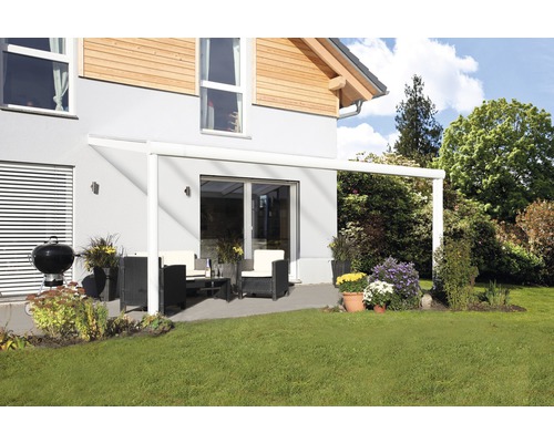 Terrasse couverte avec mobilier de jardin et barbecue à côté de la maison