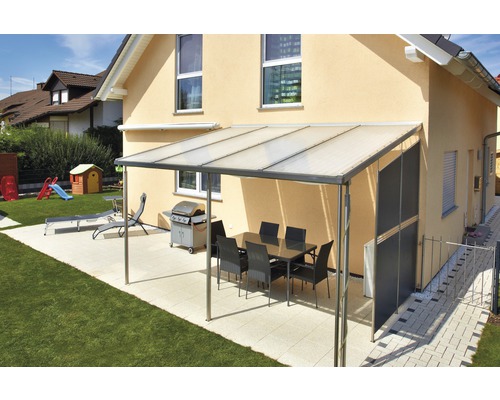 Überdachte Terrasse mit Esstisch, Grill und Liegestuhl im Garten.