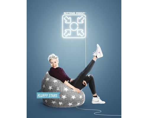 Femme assise dans un pouf gris à motif étoilé sous un logo ''Sitting Point''