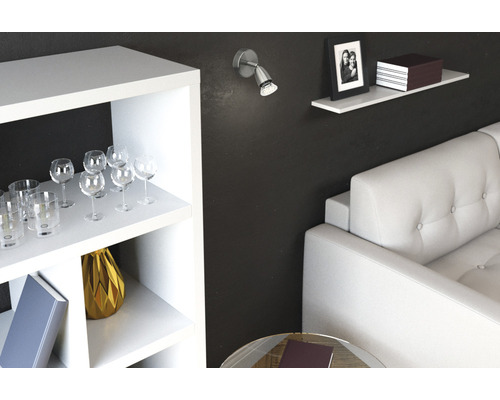 Scène de salon avec étagères, verres, lampe et canapé