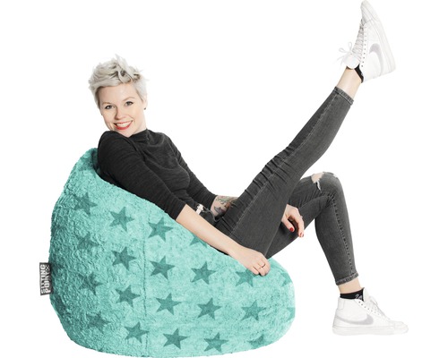Femme assise sur un pouf de couleur claire avec un motif d''étoiles.