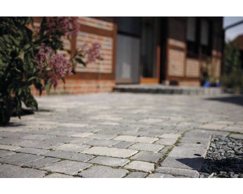 Gepflasterte Auffahrt mit Haus im Hintergrund.