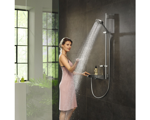Femme sous un set de douche avec douchette et étagère dans la salle de bain